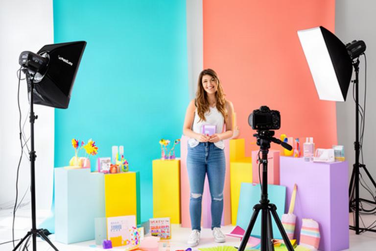 Content creator arranging a social campaign shoot in a bright studio with coloured backdrops